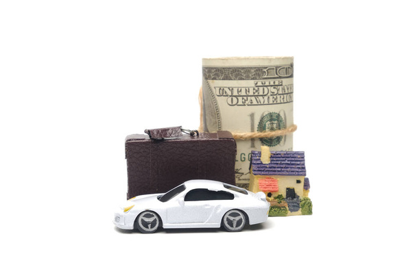 Una foto del coche diorama, maletín, miniatura de la casa y rollo de dinero falso. Concepto de gestión de activos - Foto, Imagen