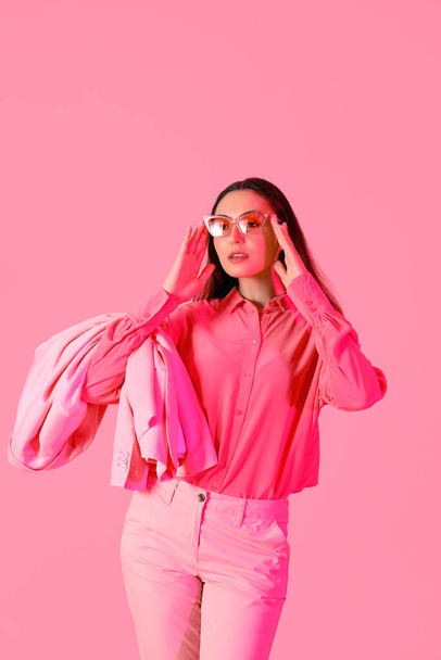 Young woman in stylish suit on pink background - Photo, Image