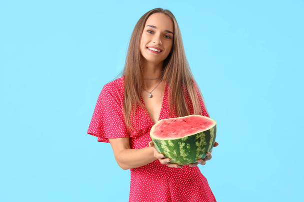 Jonge vrouw met verse watermeloen op blauwe achtergrond - Foto, afbeelding