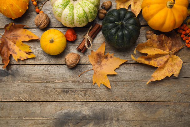 Композиція з гарбузами та осіннім листям на коричневому дерев'яному фоні - Фото, зображення