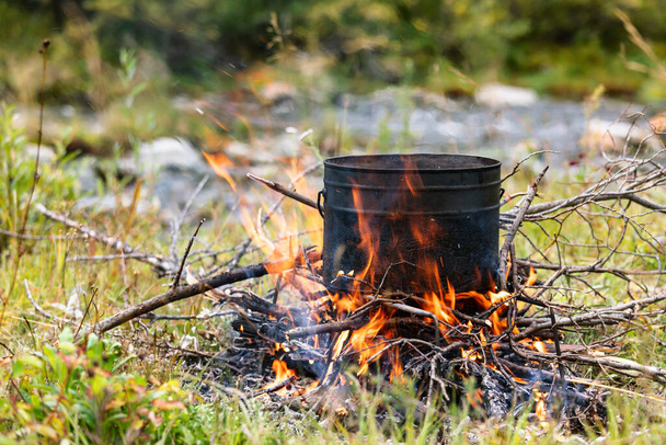 Ruoanlaitto ateria potin palavan nuotion aikana villi camping - Valokuva, kuva