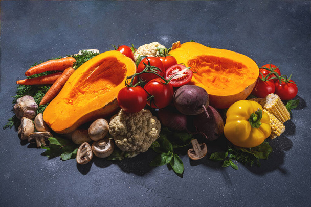 Herbst Gemüse Kochen Hintergrund. Bio-Herbsternte Bauerngemüse, Pilze. Verschiedene vegetarische Zutaten zum Kochen von Abendessen auf schwarzem Küchenhintergrund, Kopierraum von oben - Foto, Bild