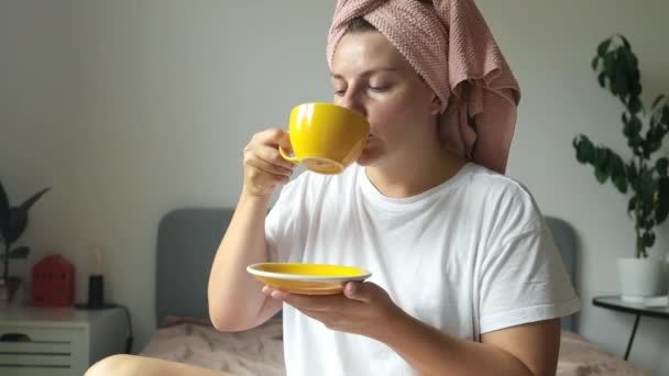 Beautiful relaxed woman, thinking and drinking coffee in bed to relax in morning with a smile and comfort. Female person in a bedroom with a tea cup for wake up, happy memory and wellness in an - Footage, Video