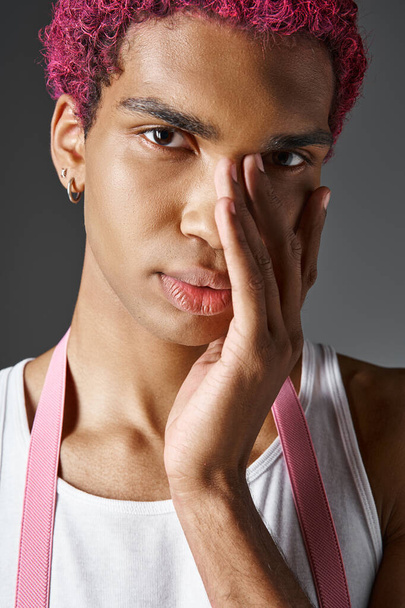 портрет красивого розового мужчину с ладонью на лице, смотрящего на камеру, моду и стиль - Фото, изображение