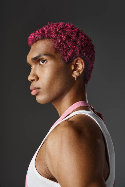 portré fiatal jóképű férfi rózsaszín haj és fülbevaló pózol profil, divat és stílus - Fotó, kép