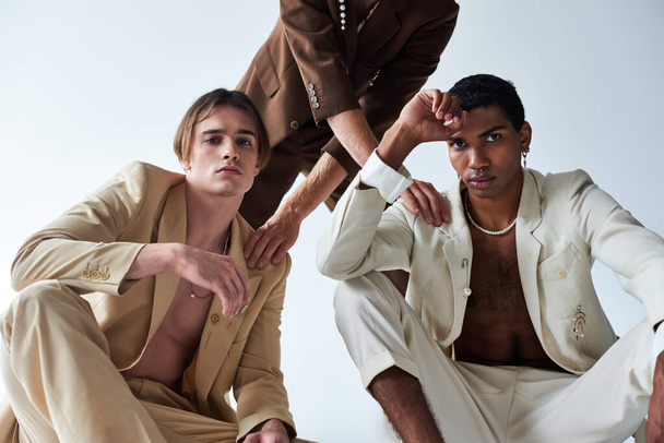cropped view of man in brown suit putting his hand on shoulders of other men, diverse, fashion - Foto, Imagem