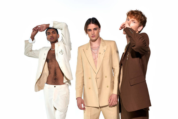 привлекательные мультикультурные мужчины в стильных ярких нарядах, активно жестикулирующие и смотрящие в камеру - Фото, изображение