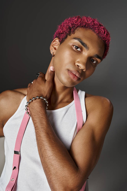 portrait of pink haired man in voguish vibrant outfit with hand on his neck, fashion concept - Photo, Image