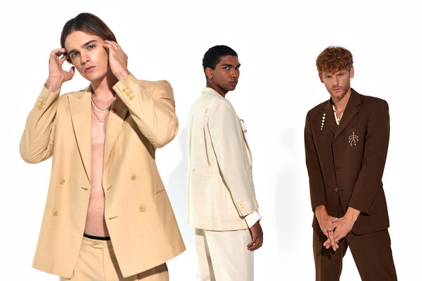 kolme tyylikäs monikulttuurinen miesten elinvoimainen puvut tarvikkeet poseeraa valkoisella taustalla - Valokuva, kuva