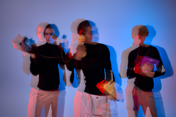 przystojny młody wielokulturowy mężczyźni z retro telefony pozowanie razem, neony światła, długa ekspozycja - Zdjęcie, obraz