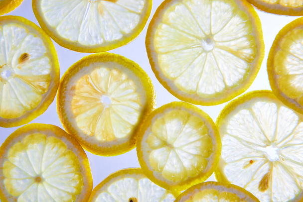 Afbeelding van Close up witte achtergrond met zie door citroenschijfjes en zichtbare zaden - Foto, afbeelding