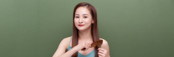 asian  girl with hair comb isolated over white banner background - Photo, Image