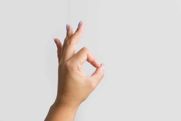 Ženská ruka ukazující ok gesto izolované na bílém pozadí. Podpis na ruce. - Fotografie, Obrázek