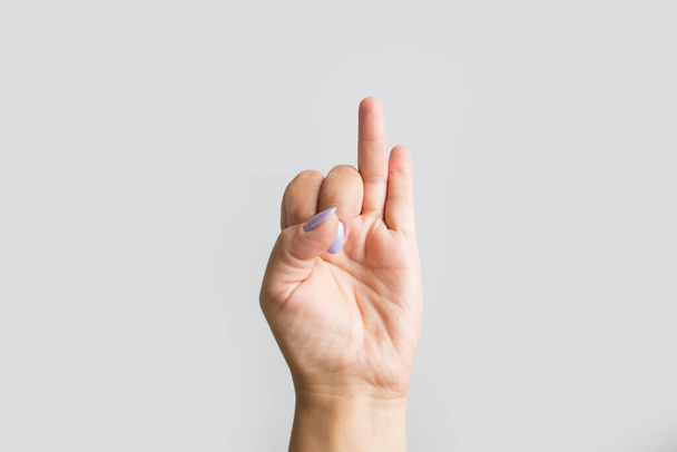 Close-up da mão de uma mulher contando o número 2, mostrando os dois dedos mais externos para cima - Foto, Imagem