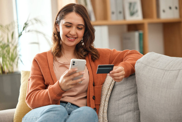 Home, woman and cellphone with credit card, online shopping and investment in a lounge. Person, girl and consumer on a sofa, smartphone and banking with payment, finance and ecommerce with budget. - Photo, Image