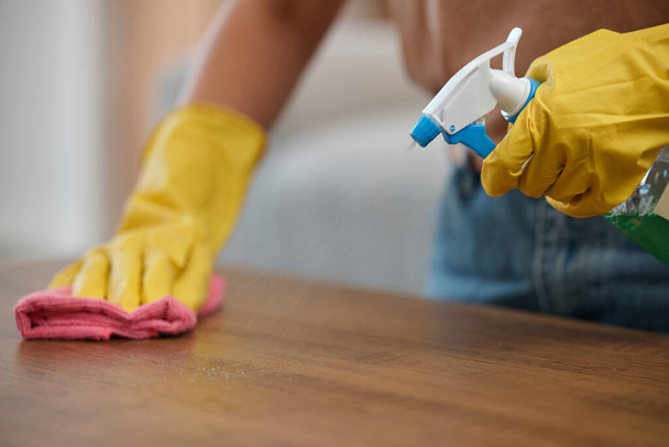 Person, cleaning and table with gloves, spray and closeup by maintenance, housekeeping and detergent for bacteria. Hands, cloth and fresh for service, cleaner and home by chemical, furniture and dust. - Photo, Image