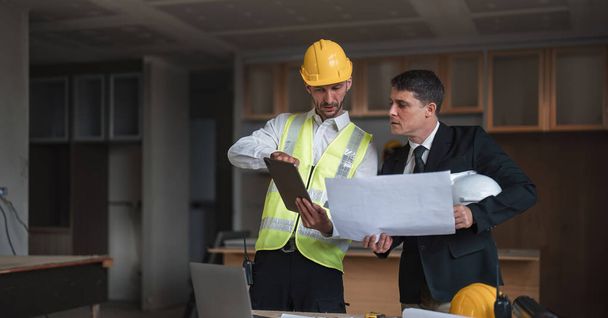 Diverse Team of Specialists Use Laptop on Construction Site. Real Estate Building Project with Engineer Investor and Businessman Checking Area, working on Civil Engineering, Discussing Strategy Plan. - Фото, изображение