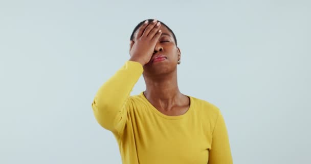 Facepalm, fallar o error con una mujer negra frustrada en el estudio sobre un fondo azul sentirse molesto. Estrés, emoji o error y un joven infeliz en crisis con un problema, arrepentimiento o preocupación. - Imágenes, Vídeo