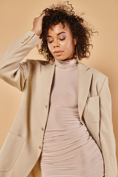 fall fashion, curly african american woman posing in autumn dress and blazer on beige backdrop - Photo, Image