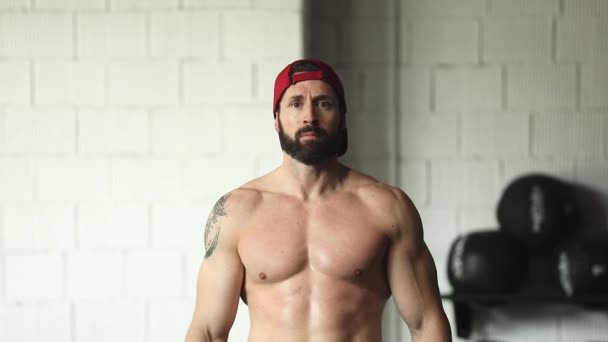 joven musculoso hombre posando en gimnasio - Metraje, vídeo