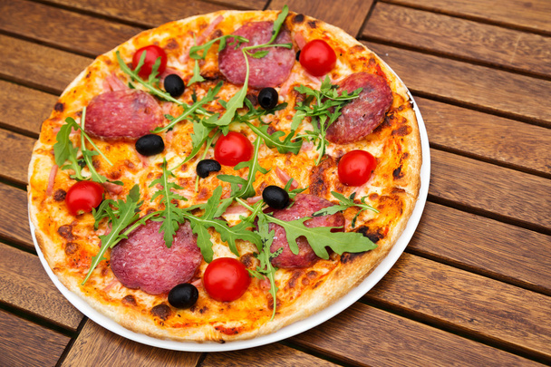 leckere italienische Pizza auf Holztisch serviert - Foto, Bild