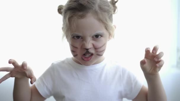 мила дівчина з сердитим котом намальованим обличчям - Кадри, відео