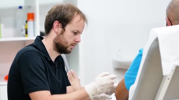 un médico masculino examina la sangre del paciente  - Imágenes, Vídeo