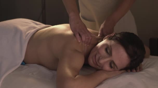 Взрослая женщина наслаждается массажем в спа-салоне - Кадры, видео