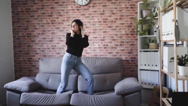Женщина танцует дома на диване - Кадры, видео