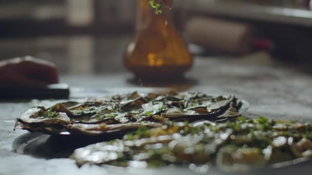 Lassú mozgás kilátás a levágott felismerhetetlen férfi séf terjed zöld petrezselyem pizza tészta, miközben előkészíti pizza étterem konyhájában - Felvétel, videó