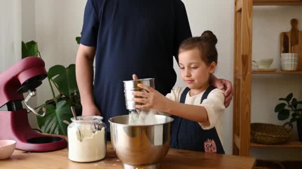Amante padre e hija tamizar la harina en un tazón de mezcla grande en casa - Metraje, vídeo