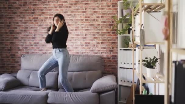 Γυναίκα χορεύει στο σπίτι στον καναπέ - Πλάνα, βίντεο