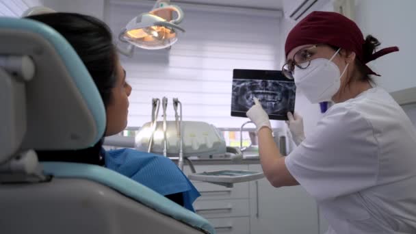 Seitenansicht eines wehmütigen Arztes in Uniform, der das Röntgenbild des Patienten untersucht, während er über die Diagnose nachdenkt - Filmmaterial, Video