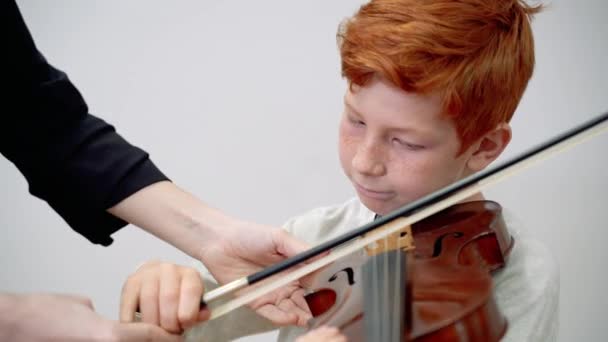 Leraar onderwijs jongen spelen viool tijdens een les - Video
