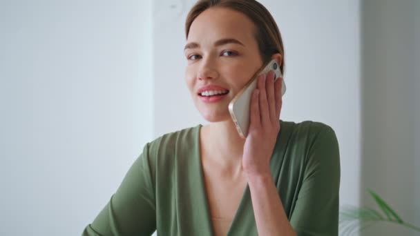 Μια σίγουρη επιχειρηματίας που μιλάει από κοντά. Ελκυστική ευτυχισμένη γυναίκα που χρησιμοποιεί το ακουστικό κινητό τηλέφωνο στο σπίτι zoom in. Όμορφη γυναίκα διευθύνων σύμβουλος μιλάει επιχειρηματικό εταίρο. Χαριτωμένο κορίτσι σε εφημερία - Πλάνα, βίντεο