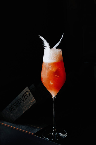 Primo piano di un cocktail rosso vicino al segno Riservato. - Foto, immagini