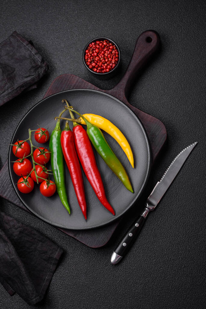 Горячий перец чили трех различных цветов красный, зеленый и желтый в качестве ингредиента для приготовления острого соуса - Фото, изображение