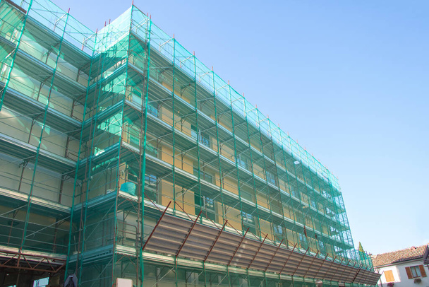 Façade du bâtiment en construction avec échafaudage et ciel bleu. - Photo, image