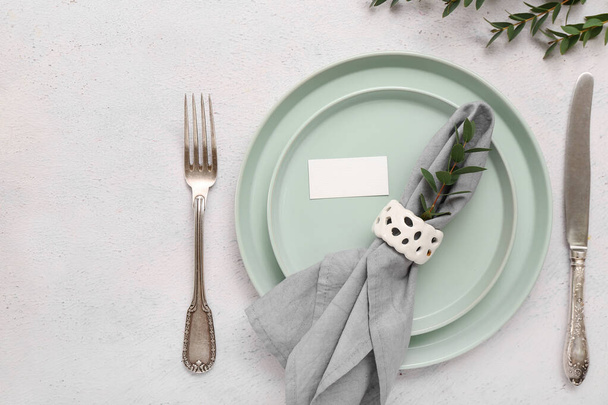 Katlanmış peçete ve beyaz seramik zemin üzerinde boş kart ile şık masa ayarları - Fotoğraf, Görsel