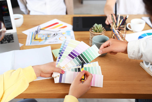 Tým grafiků pracujících s barevnými paletami u stolu v kanceláři, detailní záběr - Fotografie, Obrázek