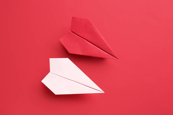 Kırmızı arkaplanda renkli origami kağıt uçaklar - Fotoğraf, Görsel