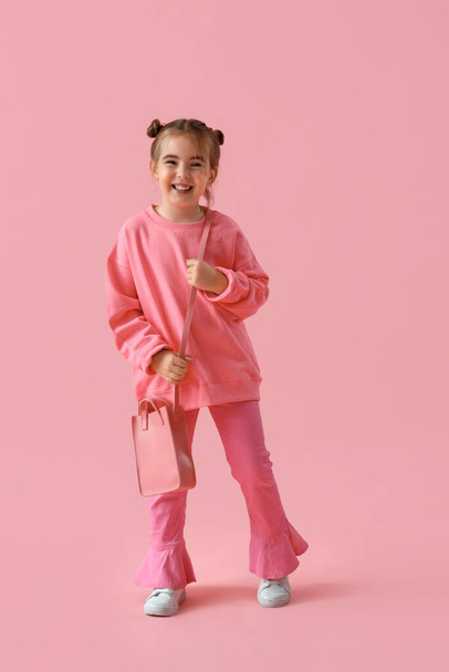 Stijlvol klein meisje op roze achtergrond - Foto, afbeelding