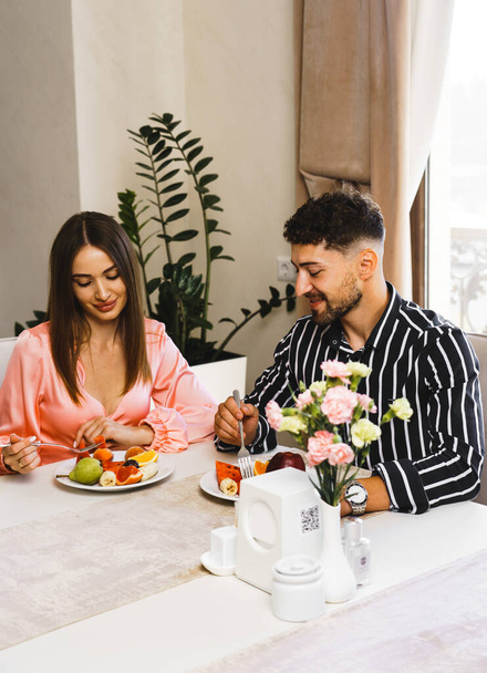 Una joven pareja enamorada está desayunando en un restaurante de un hotel. El concepto de unas vacaciones en un hotel - Foto, imagen