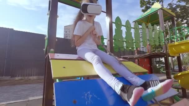 Dívka dítě hraje hru v přilbě virtuální reality. Chodí na sport v brýlích virtuální reality. - Záběry, video