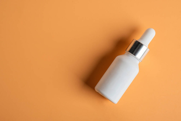 Producto cosmético en tubo, botella, loción o suero sobre fondo crema.  - Foto, imagen