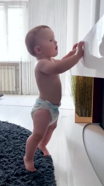 little baby is curiously looking for something on the nightstand at home. - Footage, Video