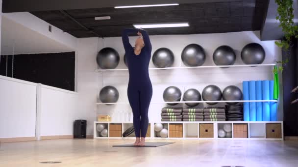 Hermosa mujer joven haciendo ejercicio en el interior, haciendo ejercicio de yoga en la habitación
 - Imágenes, Vídeo
