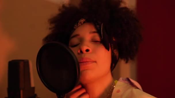 Afrykanka piosenkarka przed mikrofonem w profesjonalnym studiu nagraniowym - Materiał filmowy, wideo