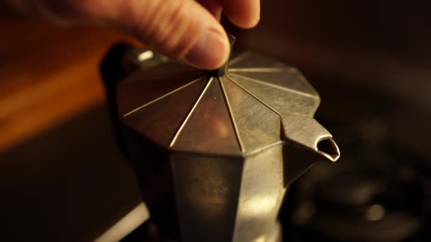 Dall'alto metallo geyser caffettiera con caffè aromatico sul fuoco stufa in cucina - Filmati, video