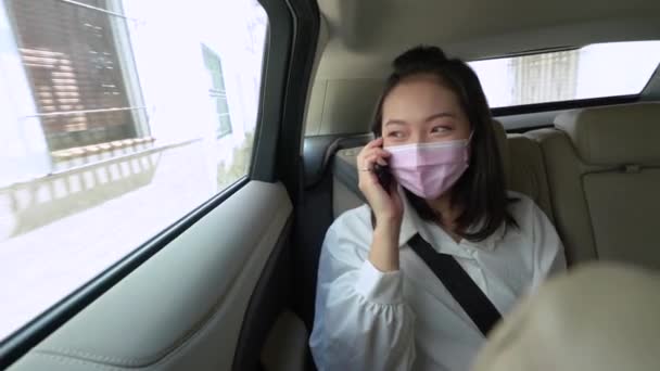 Nuori aasialainen nainen käyttää puhelinta taksin päivällä  - Materiaali, video
